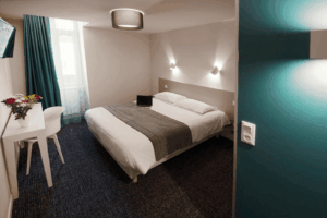 Chambre Confort de l’Hôtel du Port à Morlaix Chambre confort moderne et lumineuse de l’Hôtel du Port à Morlaix avec espace bureau et lit double confortable.